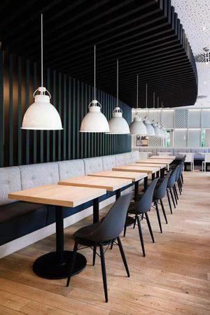 طراحی فضای نشیمن رستوران با چوب مشکی عمودی از سقف
